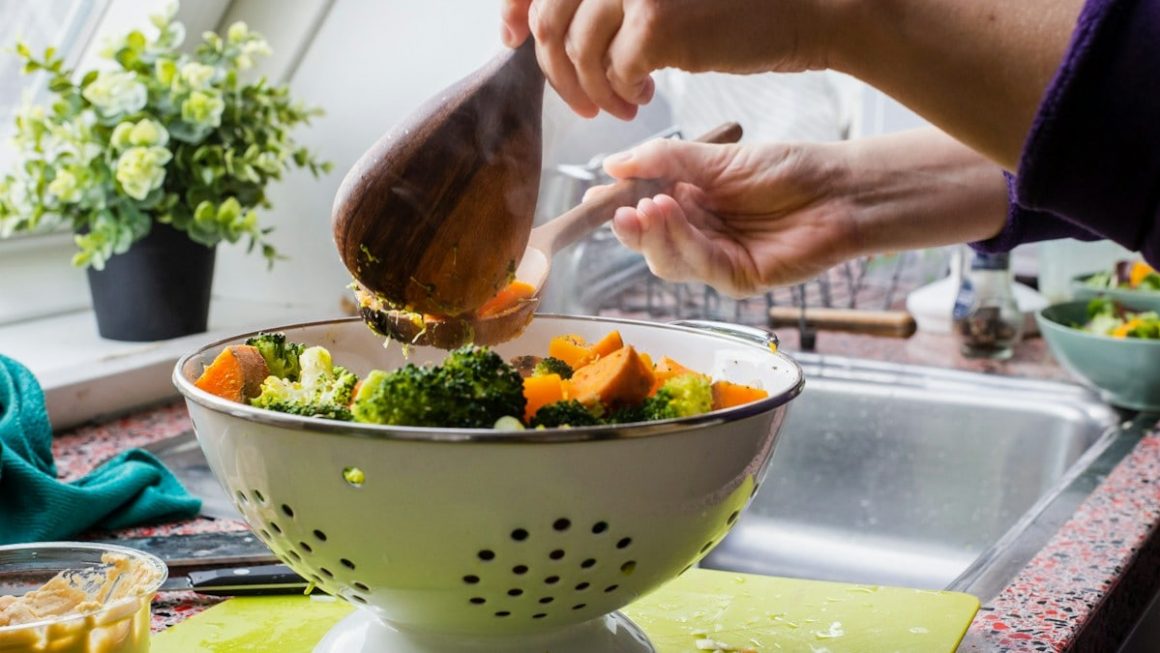 person holding brown wooden ladle